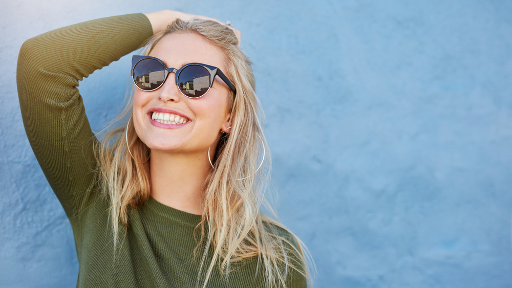 woman pulling her hair back and smiling