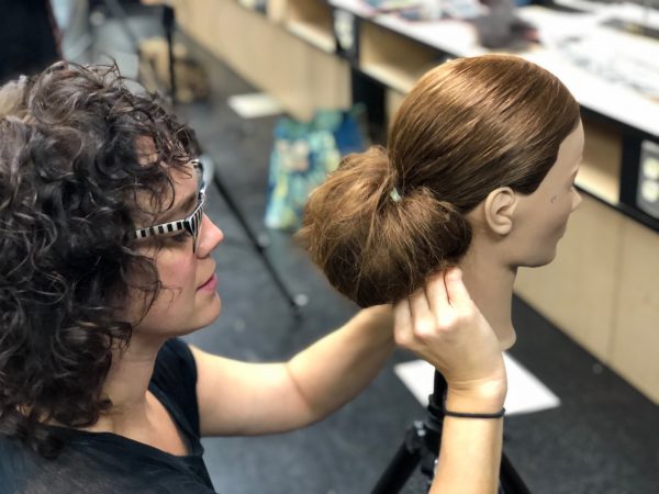 Female student styling mannequin hair