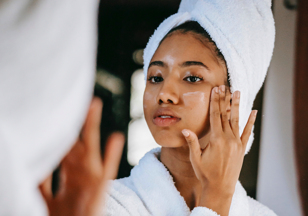 woman applying moisturizer to her face